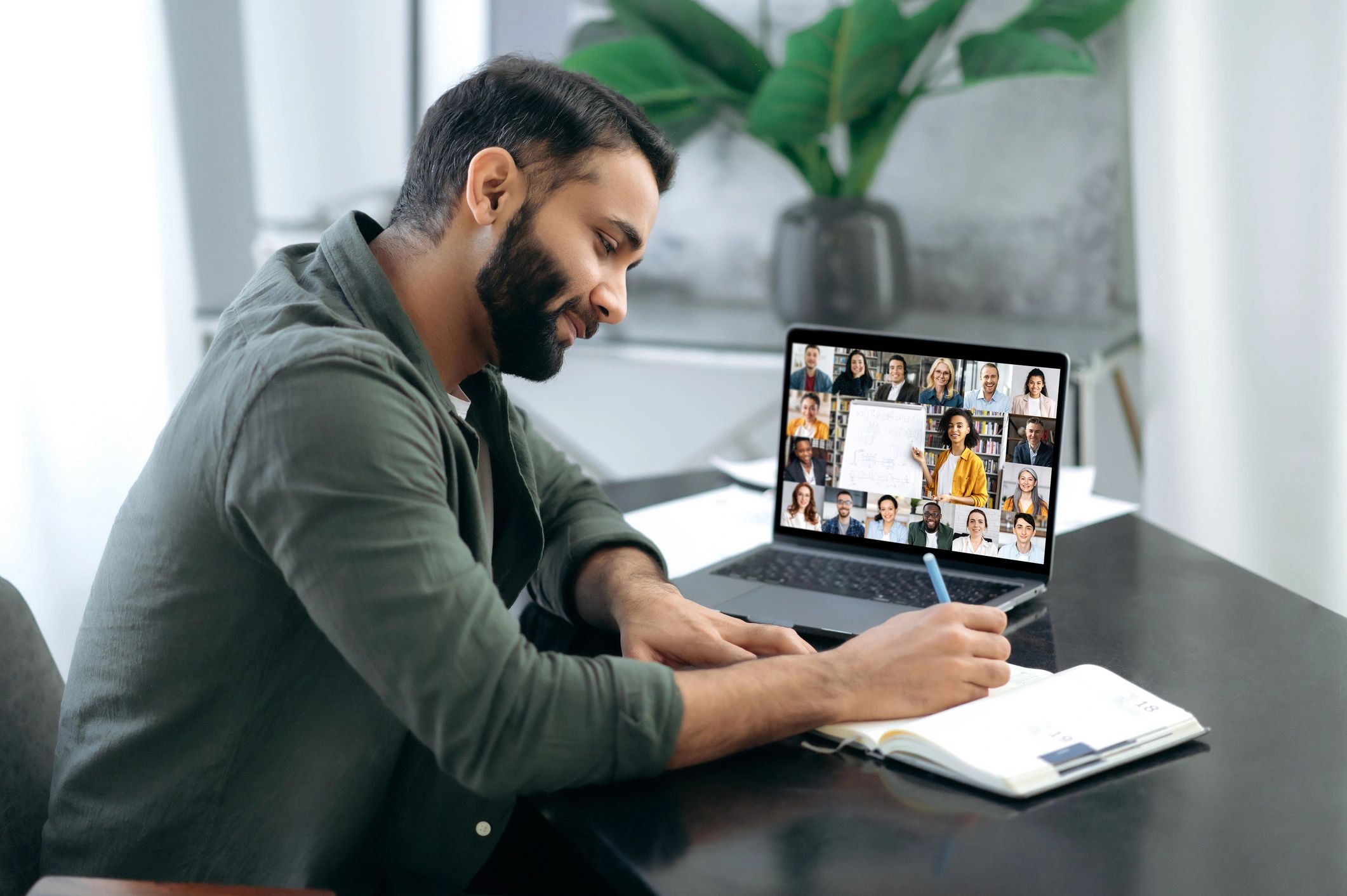 A man sitting at a table with a laptop.